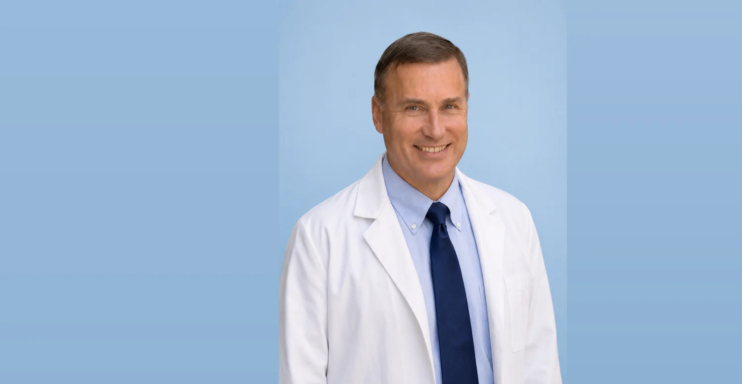 Dr. Jerry Hric smiling in his white coat